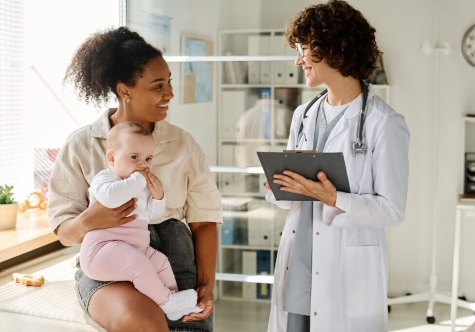 Mother with baby consulting a doctor.
